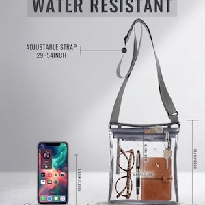 Peut inclure: Sac bandouli&egrave;re transparent et r&eacute;sistant &agrave; l'eau avec une bandouli&egrave;re grise r&eacute;glable. Le sac contient des lunettes, un stylo, un petit portefeuille marron et des cl&eacute;s. Le sac mesure 22,5 cm de large, 26 cm de haut, et la bandouli&egrave;re s'ajuste de 73,7 cm &agrave; 137,2 cm.