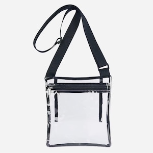 Peut inclure: Sac bandouli&egrave;re transparent avec une bandouli&egrave;re noire r&eacute;glable et une fermeture &eacute;clair noire. Le sac est rectangulaire et transparent, permettant de voir le contenu. La bandouli&egrave;re mesure environ 122 cm.