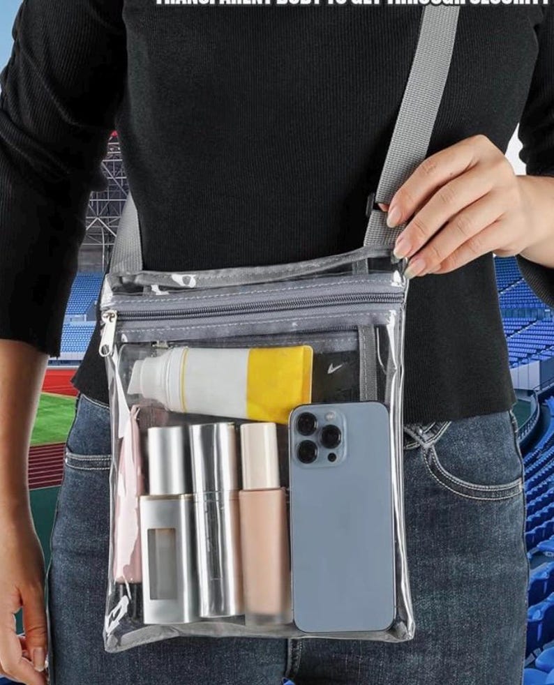 Peut inclure: Sac bandouli&egrave;re transparent avec une sangle grise, contenant un t&eacute;l&eacute;phone, des cosm&eacute;tiques et un tube de cr&egrave;me solaire. Le sac est clair, permettant de voir le contenu. Le texte en haut indique: TRANSPARENT BODY TO GET THROUGH SECURITY.