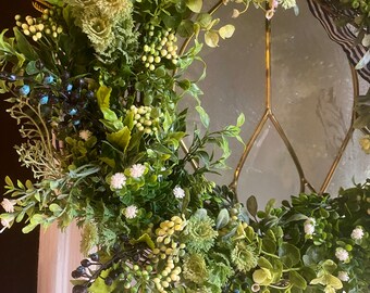 Front door wreath with mixed greenery and white flowers and blueberries