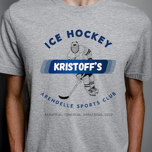 May include: Gray t-shirt with a graphic of a hockey player and the text "ICE HOCKEY KRISTOFF'S ARENDELLE SPORTS CLUB BEAUTIFUL, POWERFUL, DANGEROUS, COLD"