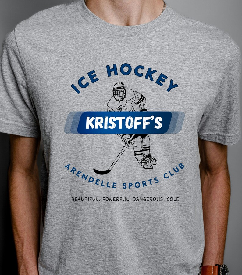 May include: Gray t-shirt with a graphic of a hockey player and the text "ICE HOCKEY KRISTOFF'S ARENDELLE SPORTS CLUB BEAUTIFUL, POWERFUL, DANGEROUS, COLD"