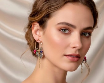 May include: Gold hoop earrings with colorful beads and heart-shaped charms. The earrings feature red, blue, and green beads, with a dangling chain. The design is intricate and detailed, suitable for a special occasion.