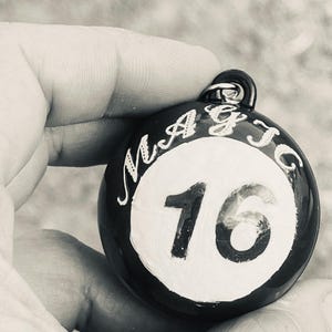 May include: A black and white round weight with the word "MAGIC" and the number "16" printed on it.