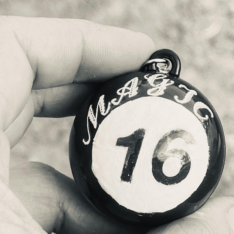 May include: A black and white round weight with the word "MAGIC" and the number "16" printed on it.