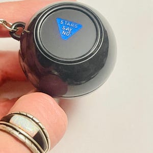 May include: A black magic eight ball keychain with a blue triangle and the text "STARS SAY NO".