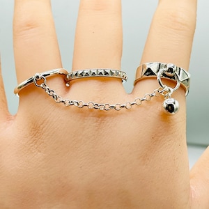 May include: A handmade wooden sign with the text "Welcome" in a playful font. The sign is painted white with a distressed finish, and features a decorative floral design in shades of pink and green. It measures approximately 12 inches wide and 6 inches tall.