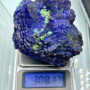 May include: A large, rough-textured azurite mineral specimen, predominantly deep blue with patches of green. The specimen is on a digital scale, displaying a weight of 308.17.