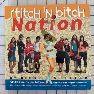 May include: A book cover with the title "Stitch 'N Bitch Nation" in large red letters. The cover features a vintage-style illustration of a woman and several other people. The book is by Debbie Stoller and includes knitting patterns.