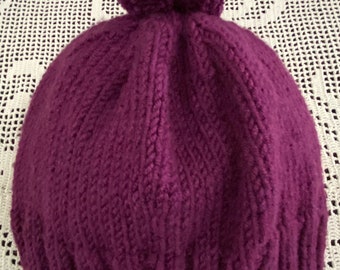 Hand-knit adult/teen sized magenta winter hat with matching yarn pompom is ready to ship.