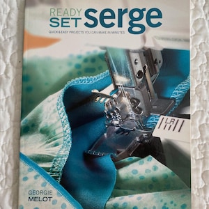 May include: A book cover titled "READY SET serge" with a sewing machine in action. The cover features a close-up of fabric in shades of teal and turquoise. The author's name, Georgie Melot, is also visible.