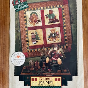 May include: A quilt pattern featuring a Christmas theme with bears and a holly bear Christmas design. The quilt pattern is surrounded by a green border with a red and white checkered pattern. The quilt pattern is titled "Holly Bear Christmas" and is part of the Debbie Mumm Friendship Club.