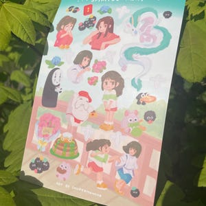 May include: A sticker sheet featuring illustrations from the animated film "Spirited Away." The sheet includes various characters and scenes, with a teal border and the film's title at the top. The artwork is colorful and detailed.