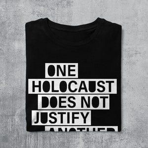 May include: Black t-shirt with white text that reads "ONE HOLOCAUST DOES NOT JUSTIFY ANOTHER".
