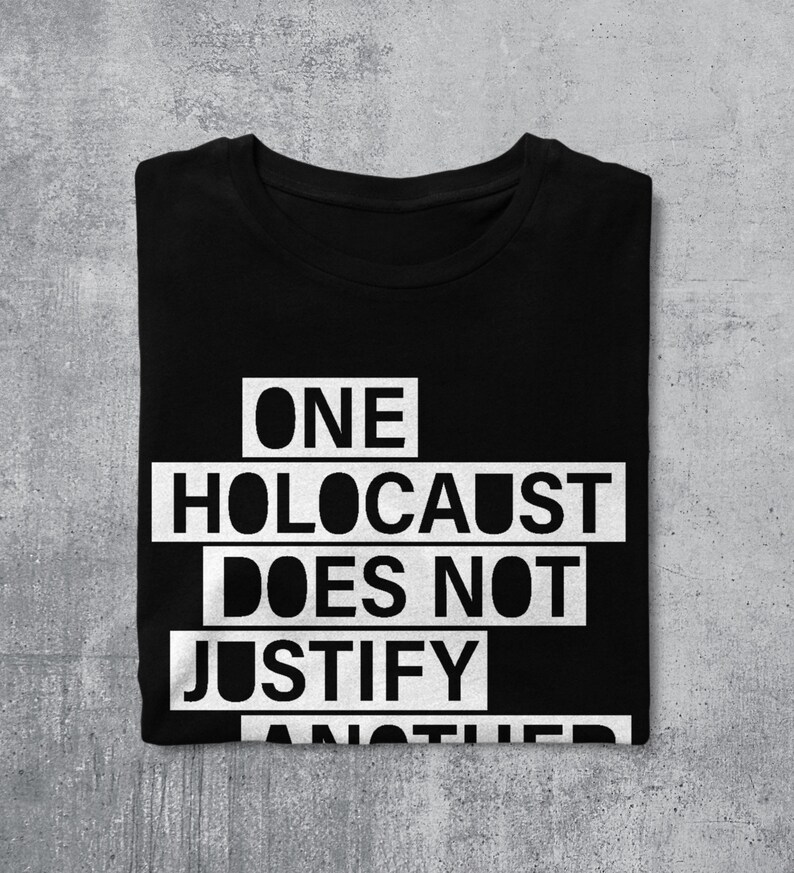 May include: Black t-shirt with white text that reads "ONE HOLOCAUST DOES NOT JUSTIFY ANOTHER".
