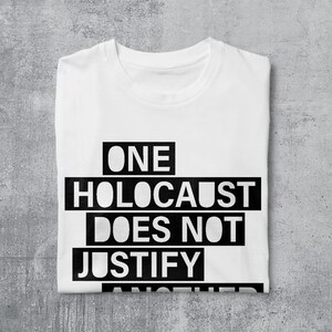 May include: White t-shirt with black text that reads "ONE HOLOCAUST DOES NOT JUSTIFY ANOTHER"