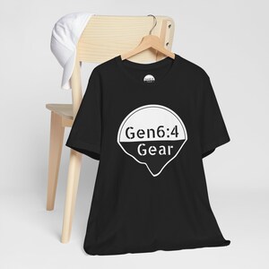 Peut inclure: T-shirt noir avec un graphique blanc d'un cercle contenant le texte "Gen6:4 Gear".