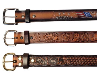 May include: Three brown leather belts with silver and gold buckles. The top belt features an American flag and the word "USA". The middle belt has embossed horseshoes, a horse, and cowboy boots. The bottom belt has an embossed design with deer and a woven pattern.