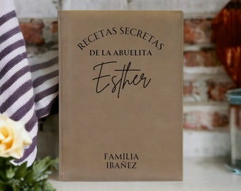 May include: A brown leather-bound recipe book with the text "RECETAS SECRETAS DE LA ABUELITA Esther FAMILIA IBAÑEZ" in black lettering.