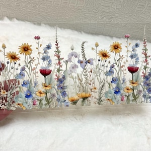 May include: A clear acrylic sheet with a watercolor design of a field of wildflowers. The flowers are in shades of blue, yellow, red, and white.