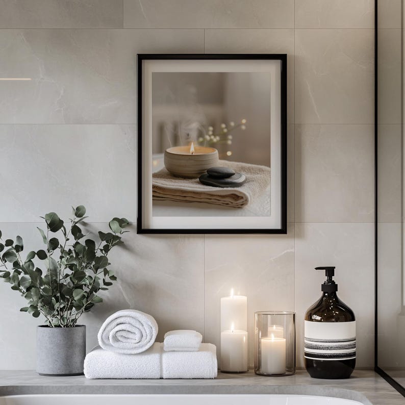 A framed digital illustration of a steaming candle resting on folded towels with smooth black stones, displayed in a modern bathroom with candles, eucalyptus, and minimalist decor to enhance a calming spa aesthetic.