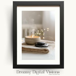 A framed digital artwork featuring a ceramic candle bowl with a warm flame and drifting smoke placed on folded neutral towels beside smooth black stones, presented in a minimalist black frame on a pale background to create a tranquil spa-inspired aesthetic ideal for calming bathroom wall art and zen home decor.