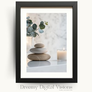 May include: A black framed wall art print featuring a stack of three smooth, neutral-toned stones, a small glass candle with a lit flame, and a sprig of eucalyptus in a glass vase. The text Dreamy Digital Visions Home Decoration is below.