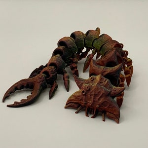 May include: A 3D printed, segmented, multi-legged creature with a segmented tail and a pair of pincers. The creature is painted in shades of brown, green, and orange.