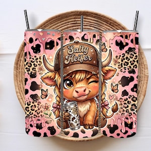 May include: Three 20 oz. stainless steel tumblers with a cartoon cow design. The cow is wearing a hat that says "Salty Heifer" and holding a coffee cup. The tumblers have a pink and black cow print design with a black straw.