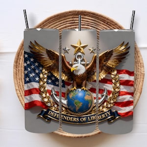 May include: A gray tumbler featuring a detailed design of an eagle with outstretched wings, the American flag, and the words "DEFENDERS OF LIBERTY." The design includes a globe, anchors, and stars, with a black straw.