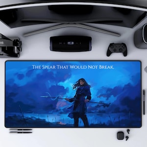 May include: A blue and white gaming mouse pad with a blue sky background and a woman holding a spear. The text "THE SPEAR THAT WOULD NOT BREAK." is printed on the mouse pad.