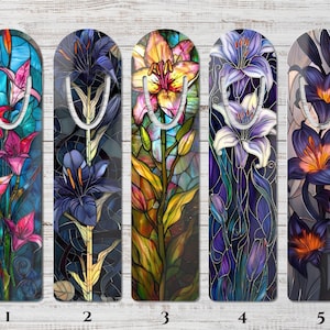 May include: Set of five decorative bookmarks featuring stained glass lily designs. Each bookmark showcases a different color palette, including pink, purple, yellow, and orange lilies. The bookmarks have a metal clip at the top.