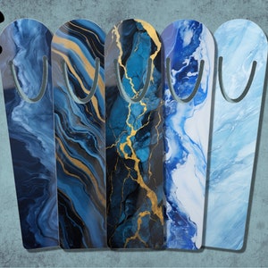 Puede incluir: Cinco clips de marcapáginas con estampado de mármol azul y dorado. Los marcapáginas son todos de diseños diferentes con remolinos de azul, negro y dorado.
