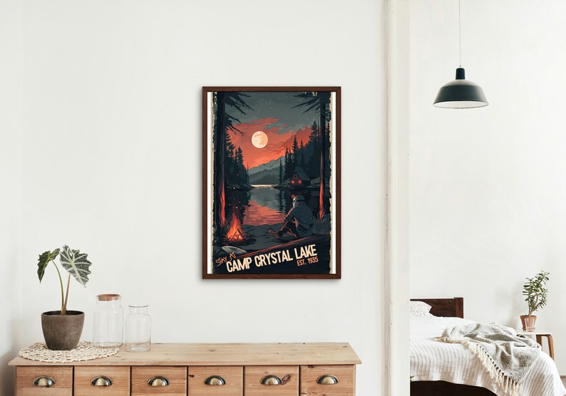 May include: A retro-style poster with a dark blue, red, and orange color scheme. It features a nighttime scene of a lake with a cabin on the shore, a campfire, and a full moon. The text on the poster reads "Stay at Camp Crystal Lake Est. 1958".