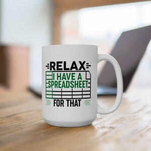May include: White ceramic coffee mug with black text that reads "=RELAX= I HAVE A SPREADSHEET FOR THAT" with a green spreadsheet icon.