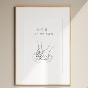 May include: Black and white line art print of two hands kneading dough with the text "LOVE is all you KNEAD" above the image.