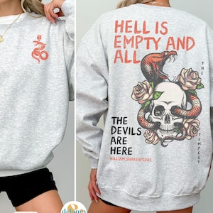 May include: Gray sweatshirt with a skull and snake graphic on the back. The text "Hell is empty and all the devils are here" is printed below the graphic. The text "William Shakespeare" is printed below the quote. The sweatshirt has a small snake graphic on the front.
