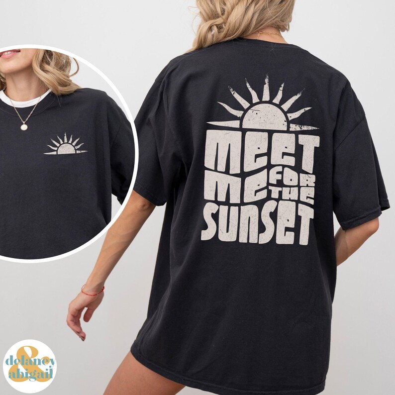 May include: Black oversized t-shirt with a white graphic print of a sun and the text "Meet Me For The Sunset".