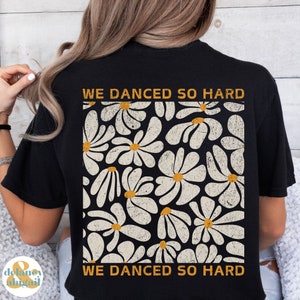 May include: Black t-shirt with a white daisy pattern and the text "WE DANCED SO HARD" in orange.