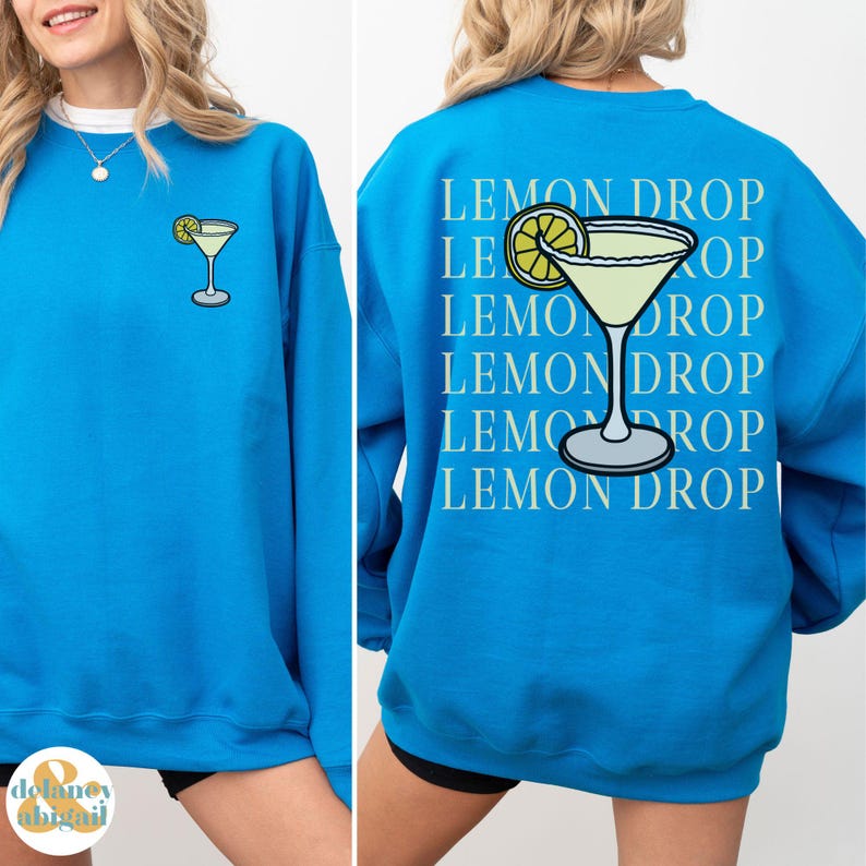 Pu&ograve; includere: Una felpa blu brillante con una grafica di martini al limone sul davanti e il testo "LEMON DROP" ripetuto sul retro.