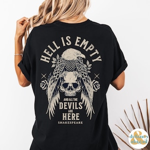 May include: Black t-shirt with a graphic of an eagle holding a skull. The text "Hell is empty and all the devils are here Shakespeare" is printed on the shirt.