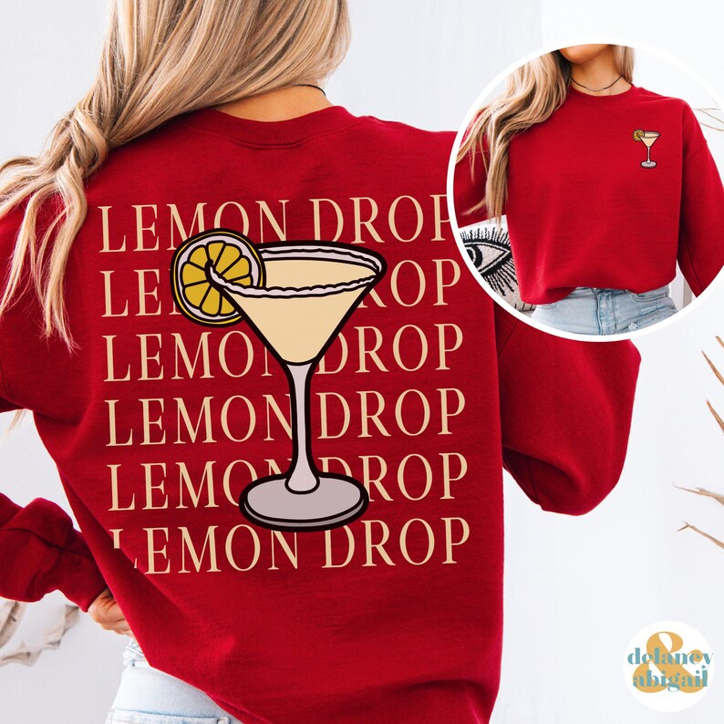 Pu&ograve; includere: Felpa rossa con il testo "Lemon Drop" ripetuto cinque volte e una grafica di un cocktail Lemon Drop sul retro.