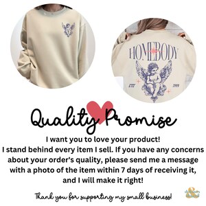 May include: Cream-colored sweatshirt featuring a cherub design on the front and back. The back design includes the word "HOMEBODY" above the cherub, with "EST 1999" below. The front has a smaller cherub graphic.