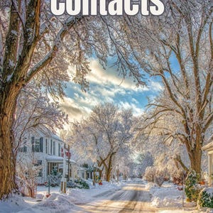May include: A snow-covered street in a residential area with the word "Contacts" in the sky. The trees are covered in snow, and the sky is a mix of blue and clouds. The road is clear of snow.