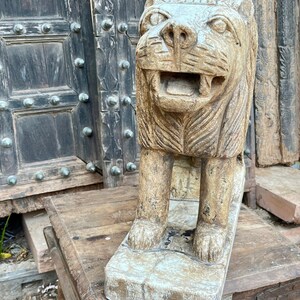Puede incluir: Una estatua de le&oacute;n de piedra tallada con un rostro y una melena detallados. La estatua est&aacute; de pie sobre una base rectangular y tiene un aspecto desgastado y antiguo.