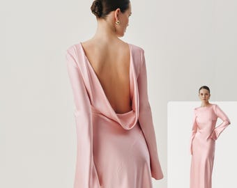 Puede incluir: Un vestido largo de satén rosa pálido con mangas largas de puños acampanados y un diseño de espalda abierta profunda. La tela tiene un acabado suave y brillante, y el vestido se muestra tanto de espaldas como de frente en vista completa.