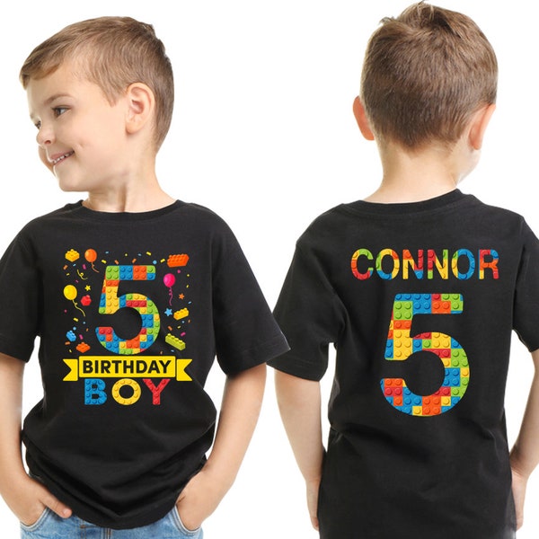 以下が含まれることがあります： カラフルなレゴブロックのデザインが施された黒いTシャツ2枚。1枚は数字の5と「Birthday Boy」の文字が書かれており、もう1枚は「Connor」の名前と数字の5が書かれています。