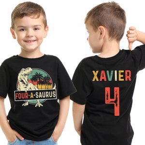 May include: Two black t-shirts with a dinosaur graphic and the text "FOUR-A-SAURUS" on the front and the name "XAVIER" and the number "4" on the back.