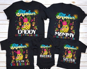 Puede incluir: Un conjunto de cinco camisetas negras con un diseño de piña y el texto "Aloha" en cada camiseta. Las camisetas dicen "Papá de la niña del cumpleaños", "Mamá de la niña del cumpleaños", "Hermano de la niña del cumpleaños", "Hermana de la niña del cumpleaños" y "Es mi 5º cumpleaños".