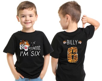 May include: Black t-shirt with a tiger graphic and the text "ROARRR I'M SIX". The back of the shirt has a tiger-striped number "6" and the name "BILLY".